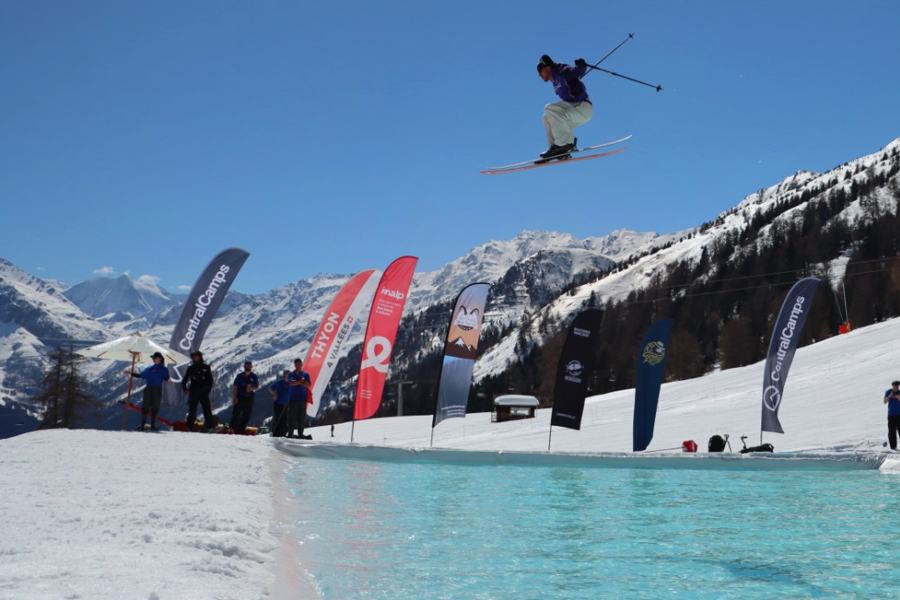 Skieur en saut au-dessus d’un bassin d’eau, entouré de banderoles